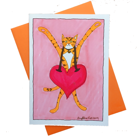 A greeting card with a drawing of an orange cat with black stripes like lightning bolts and his paws in the air. Around his neck hangs a gigantic red heart that covers his entire hip region.